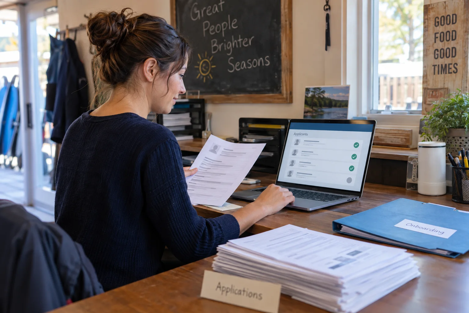 A seasonal-business manager reviewing digital job applications while moving away from a paper application process