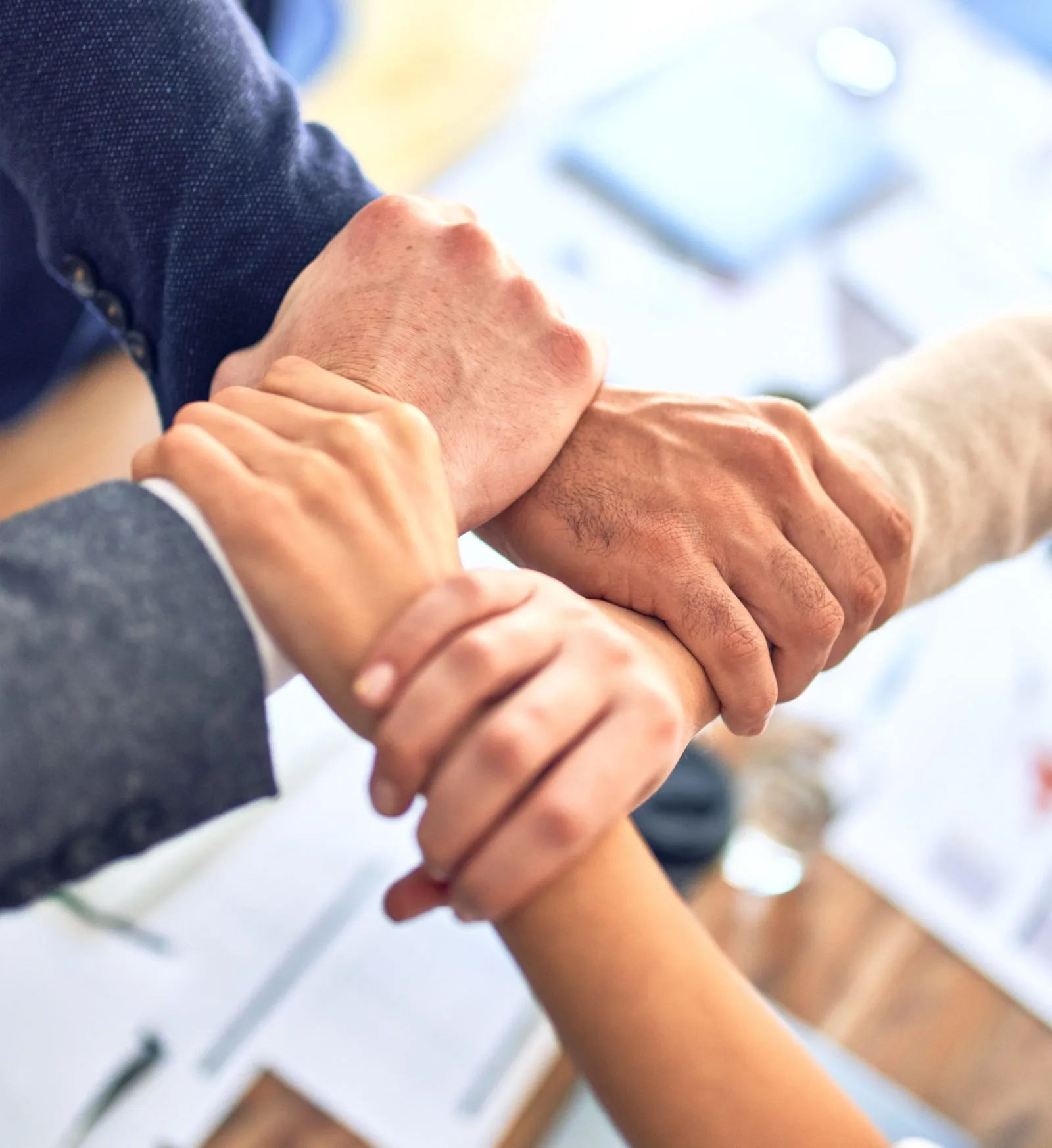A diverse group of colleagues joining hands